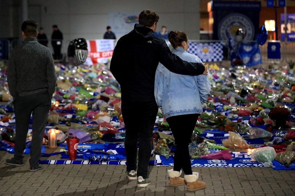 Mourners pause to pay tributes after the helicopter crash at The King Power Stadium on October 28, 2018 in Leicester, England