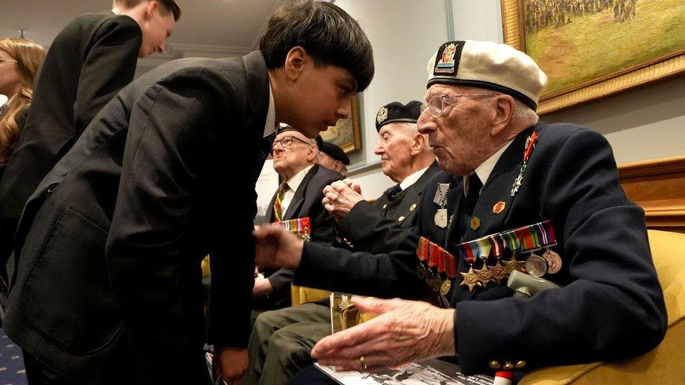 D-Day veteran Alec Penstone, who served with the Royal Navy on board the escort aircraft carrier HMS Campania during the Normandy Campaign, meets students from Kingsford Community School during 'Meet the Veterans: A History Lesson With Those Who Were There'