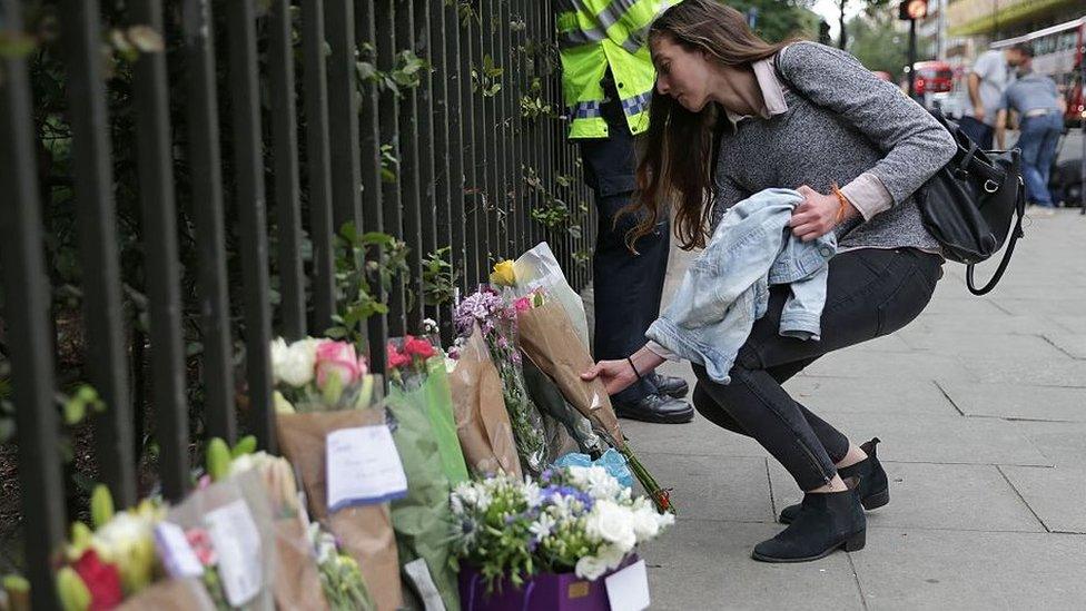 A woman lays flowers after a tourist was stabbed in Russell Square