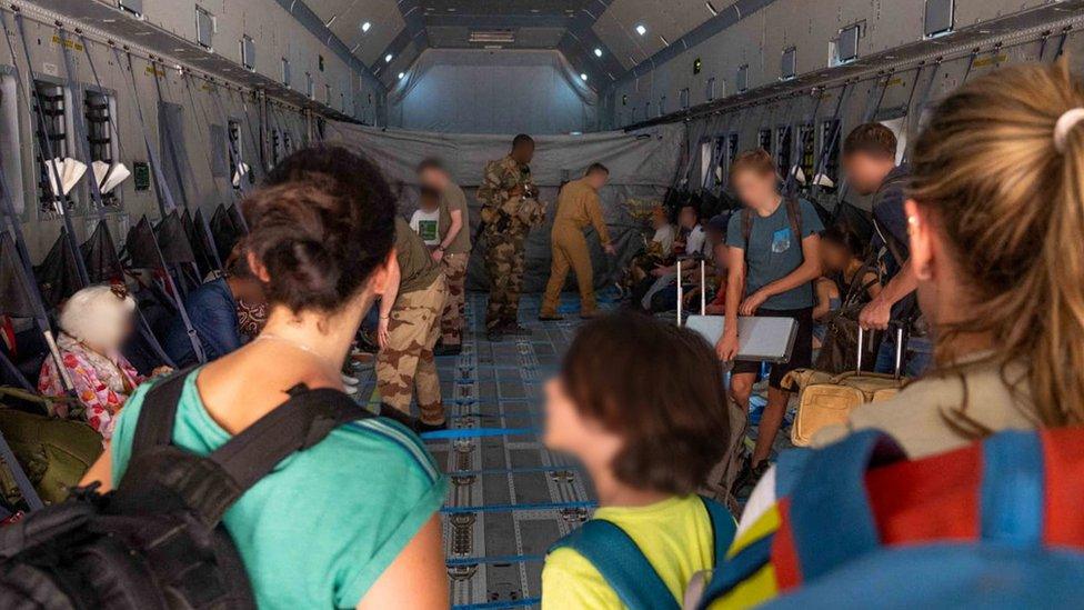 French soldiers evacuate French citizens, as part of the "Operation Sagittaire" evacuation by the French army, in Khartoum, Sudan, April 23, 2023. Etat-major des armees/Handout via REUTERS THIS IMAGE HAS BEEN SUPPLIED BY A THIRD PARTY. MANDATORY CREDIT. NO RESALES. NO ARCHIVES. FACES BLURRED AT SOURCE.