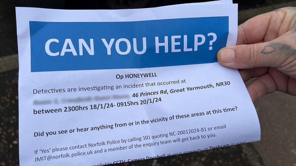 A hand holds up a police leaflet seeking information