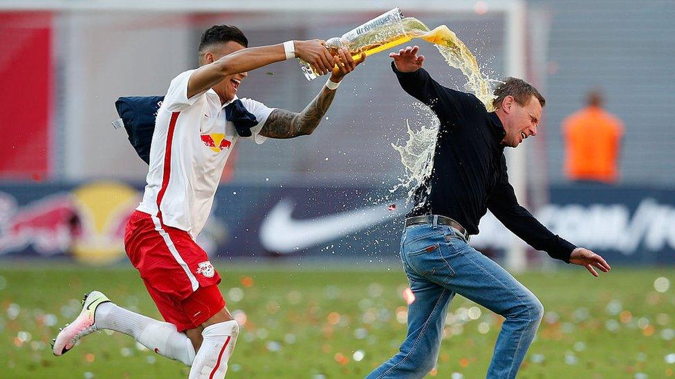 Ralf Rangnick being soaked by a RB Leipzig player after a winning game.