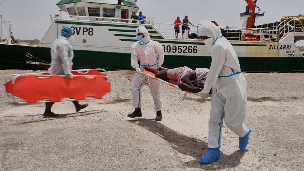 Aid workers carry an injured Senegalese man on a stretcher