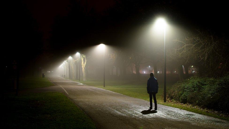 Stock image of a person walking alone at night