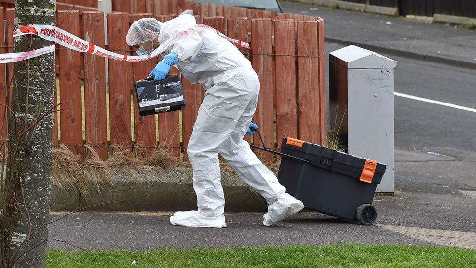 Forensic officers attended a flat in Derrycoole Way where one woman was killed