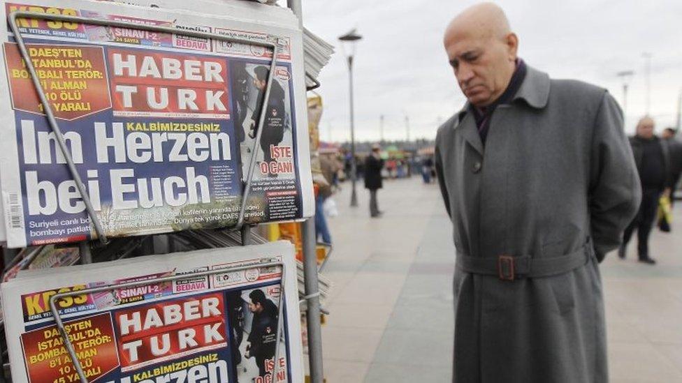 A man looks at Turkish newspapers with a German-language front page detailing the recent suicide bomb attack in Istanbul (16 January 2016)