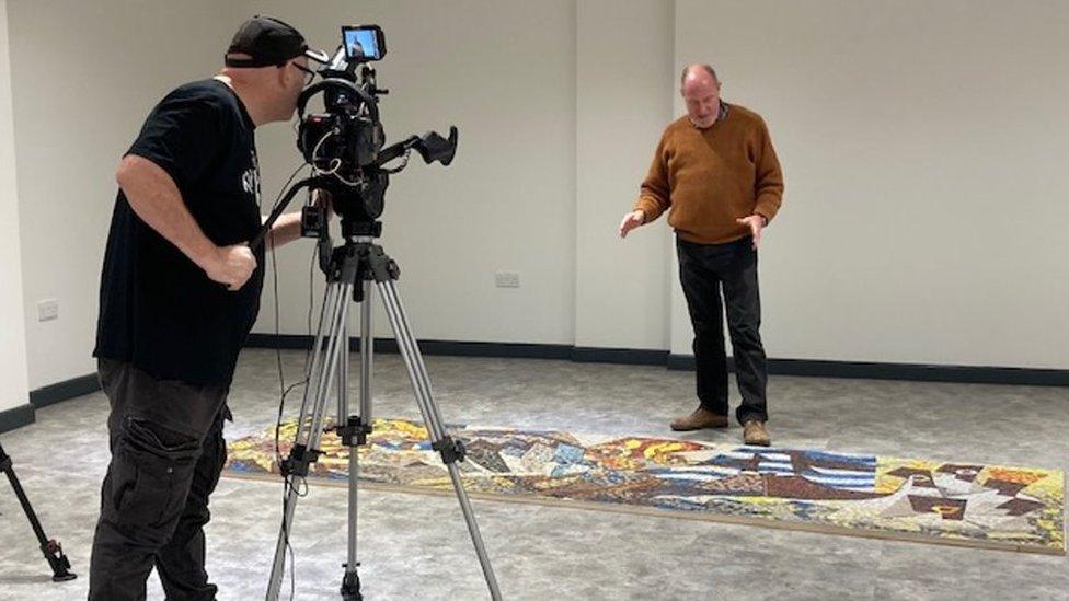 Oliver Budd with his mosaic during filming of the documentary