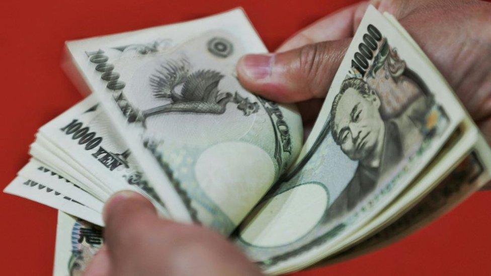 Person counting Japanese bank notes.