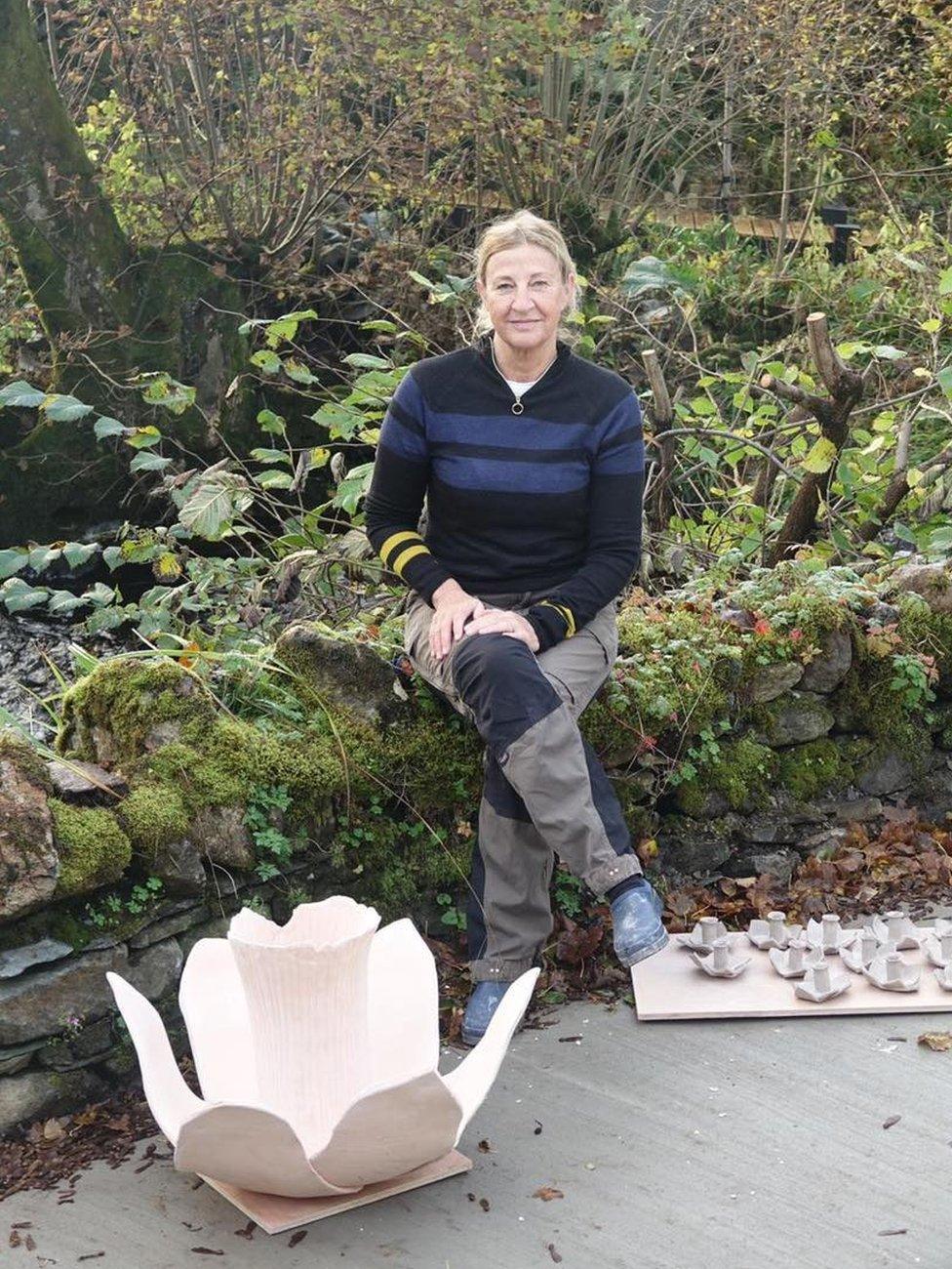 Helen Ratcliffe sitting alongside a prototype unglazed daffodil