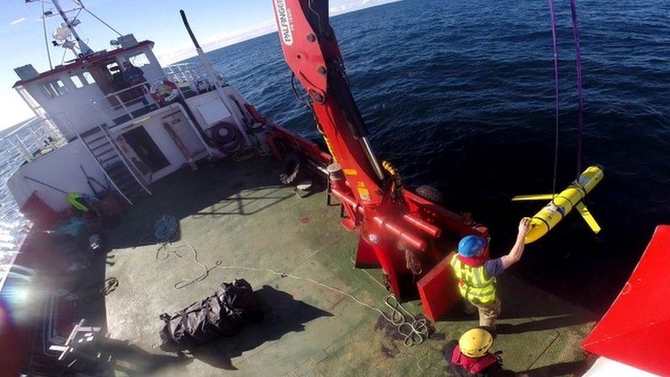 A undated Navy file photo shows crew members aboard the VOS Raasay recover US and British Royal Navy ocean gliders taking part in the Unmanned Warrior exercise off the northwest coast of Scotland in October 2016.