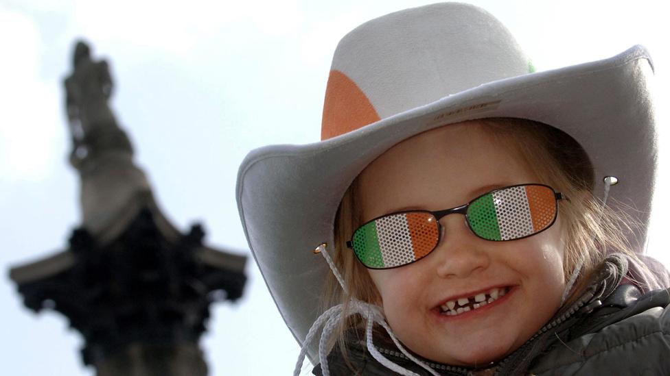 Little girl in novelty Irish sunglasses in front of Nelson's column