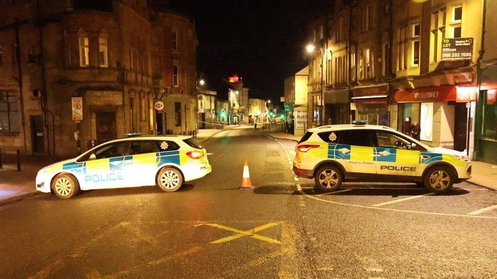 Two police cars blocking the street where officers were conducting inquiries