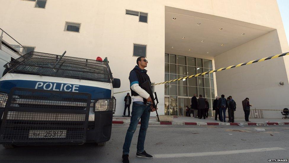 Tunisian security forces and forensic experts stand at the visitors entrance of the National Bardo Museum in Tunis on March 19, 2015, in the aftermath of an attack on foreign tourists.