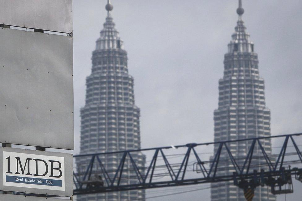 In this Wednesday, 8 July 2015 photo, a 1MDB (1 Malaysia Development Berhad) logo is set against the Petronas Twin Towers at the flagship development site, Tun Razak Exchange in Kuala Lumpur, Malaysia