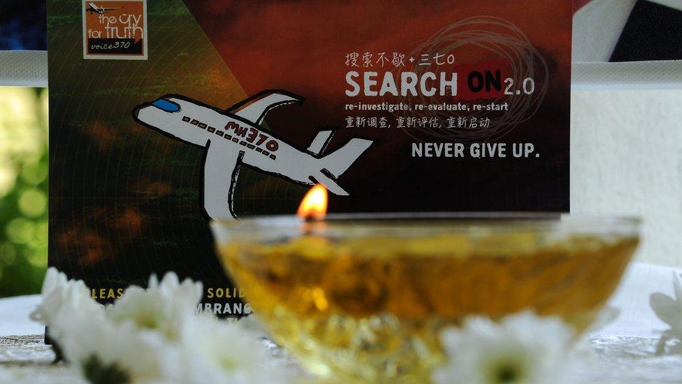 A candle burns a prayer message for passengers of missing Malaysia Airlines flight MH370 in Petaling Jaya on March 8, 2016