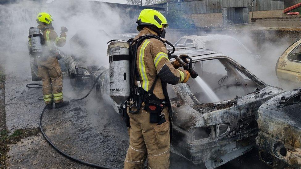 A firefighter and a burning car