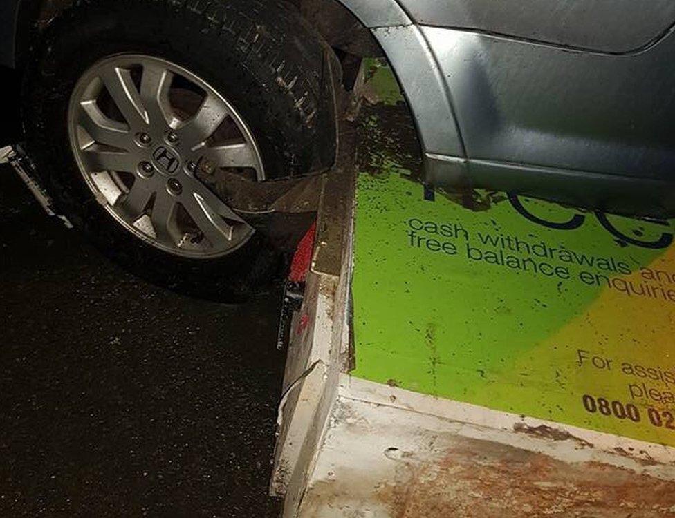 ATM wedged beneath parked car