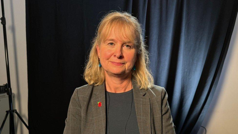 Celia Webster, a woman with light hair wearing a tweed jacket