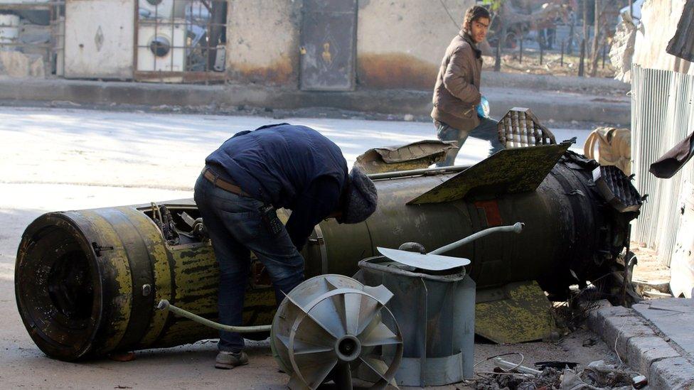 A man inspects an unexploded missile in the rebel-held Qaterji district of Aleppo (28 November 2016)