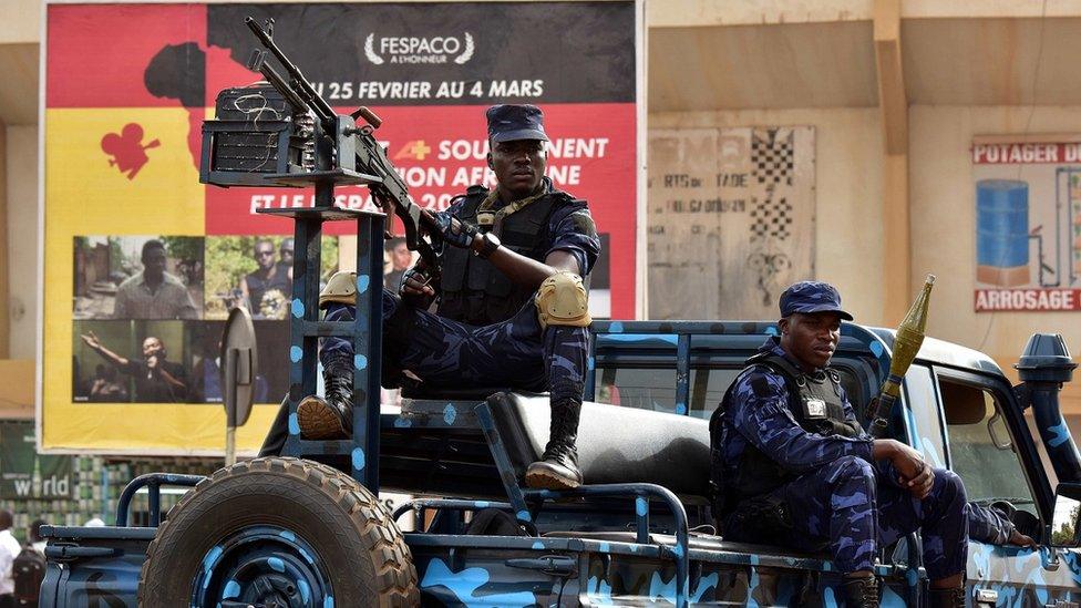 Soldiers stand guard at the entrance of the Municpal Stadium during the opening ceremony of the Fespaco