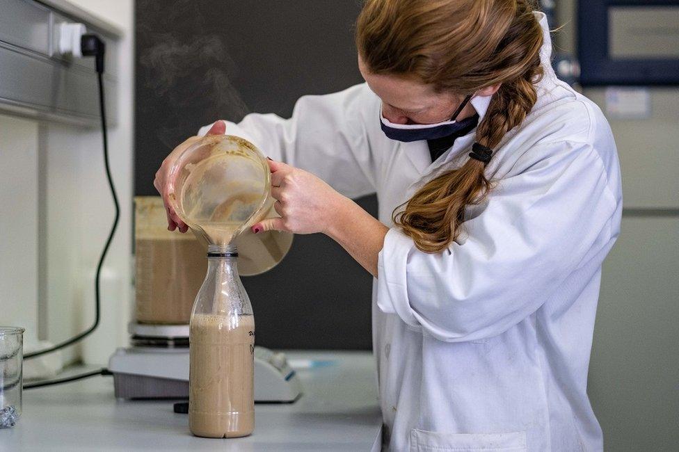 Woman pouring mixture into a bottle