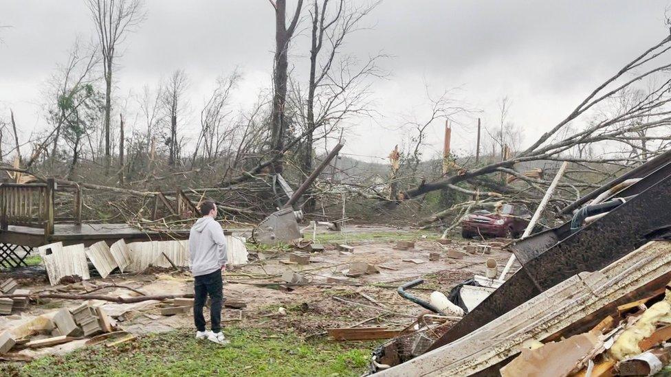 A man stands amid the wreckage in Alabama