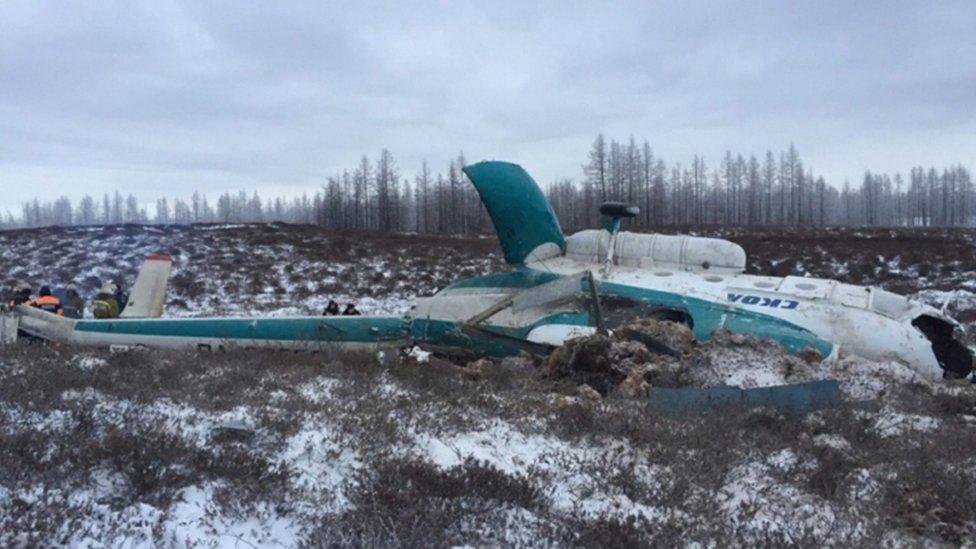 Crashed helicopter half buried in a field