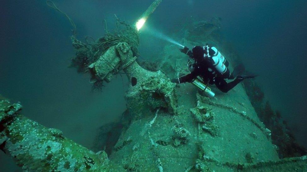 Diver Chris de Putron inspects the submarine's gun