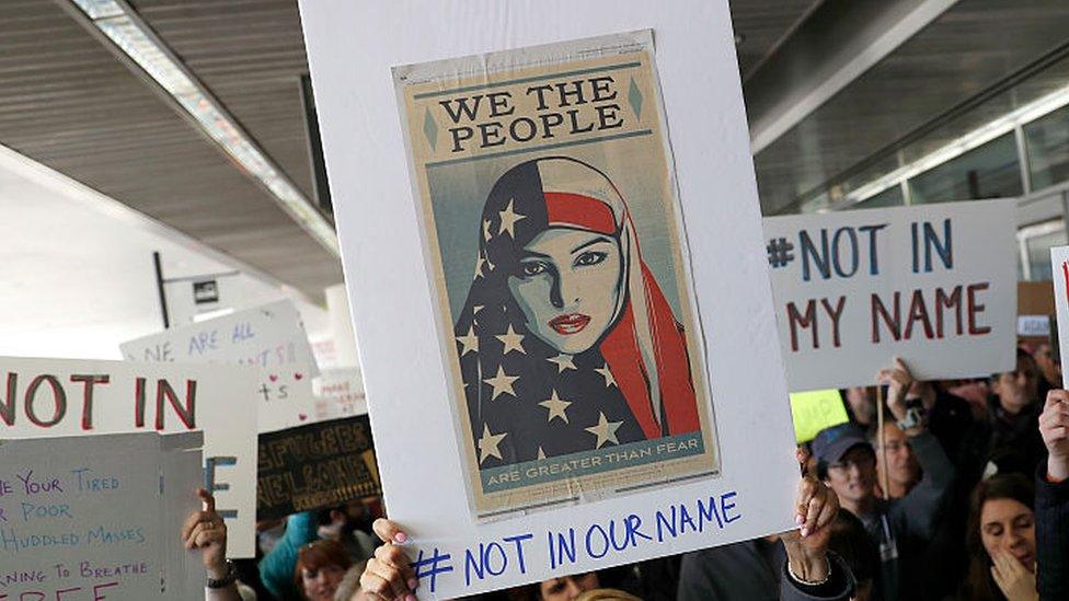 Demonstrators hold signs during a rally against a ban on Muslim immigration at San Francisco International Airport