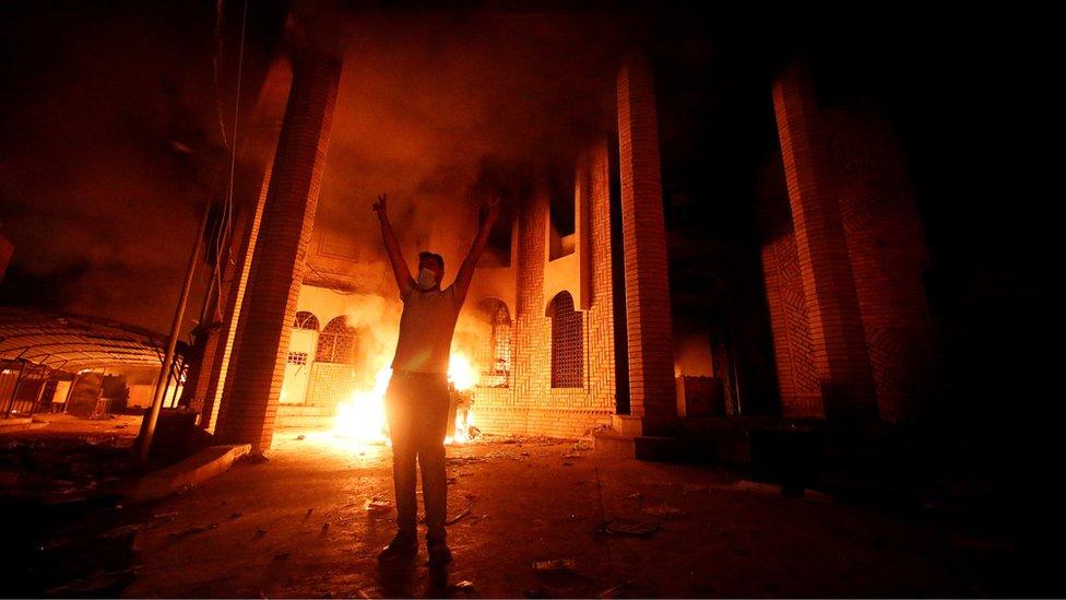 Iraqi protesters are seen near the burnt Iranian Consulate in Basra, 7 September 2018