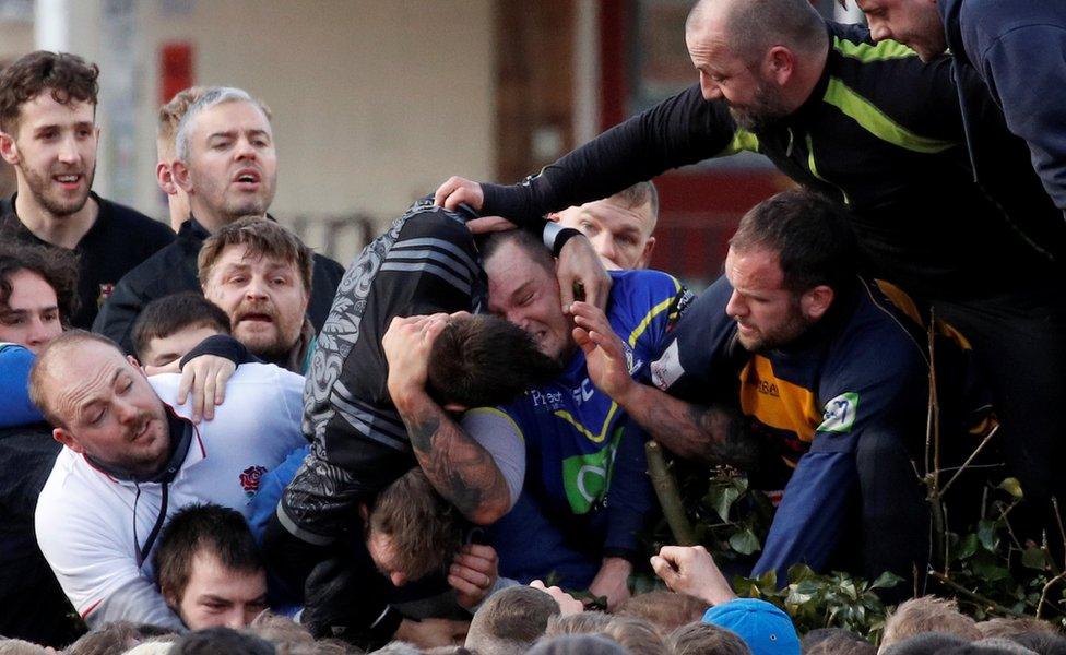 Players fight for the ball during the annual Shrovetide football match in Ashbourne