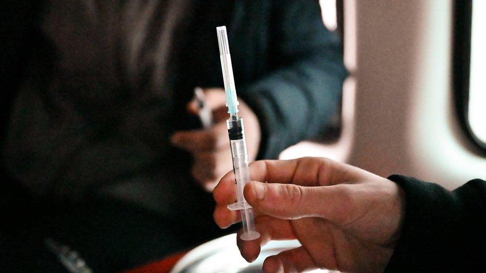 Man holding a needle inside a "safe consumption" van in Glasgow