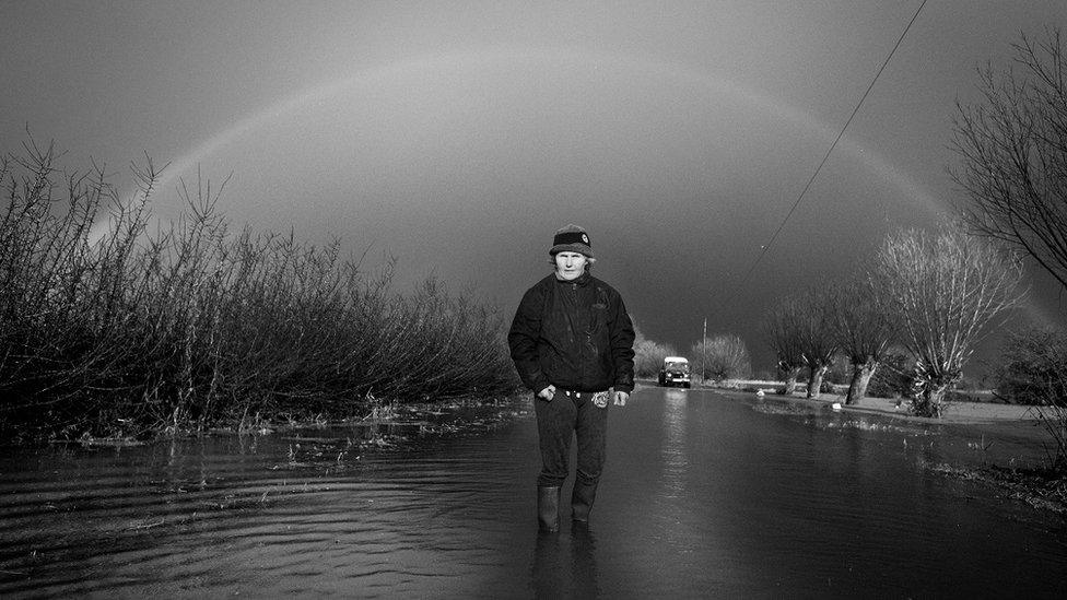 Christine Gray walking down a flooded road.