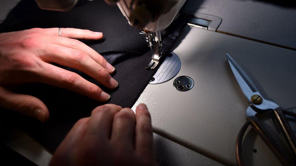 Woman sewing a seam on a garment using a sewing machine