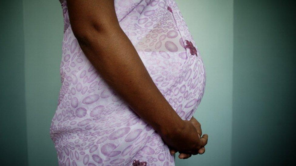 A woman holding her pregnant belly