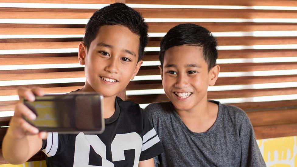 two-boys-smile-at-phone