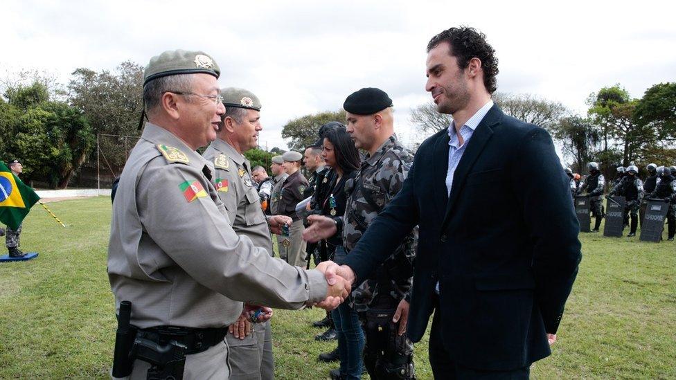 Leo Fração shakes the hand of a member of the military police