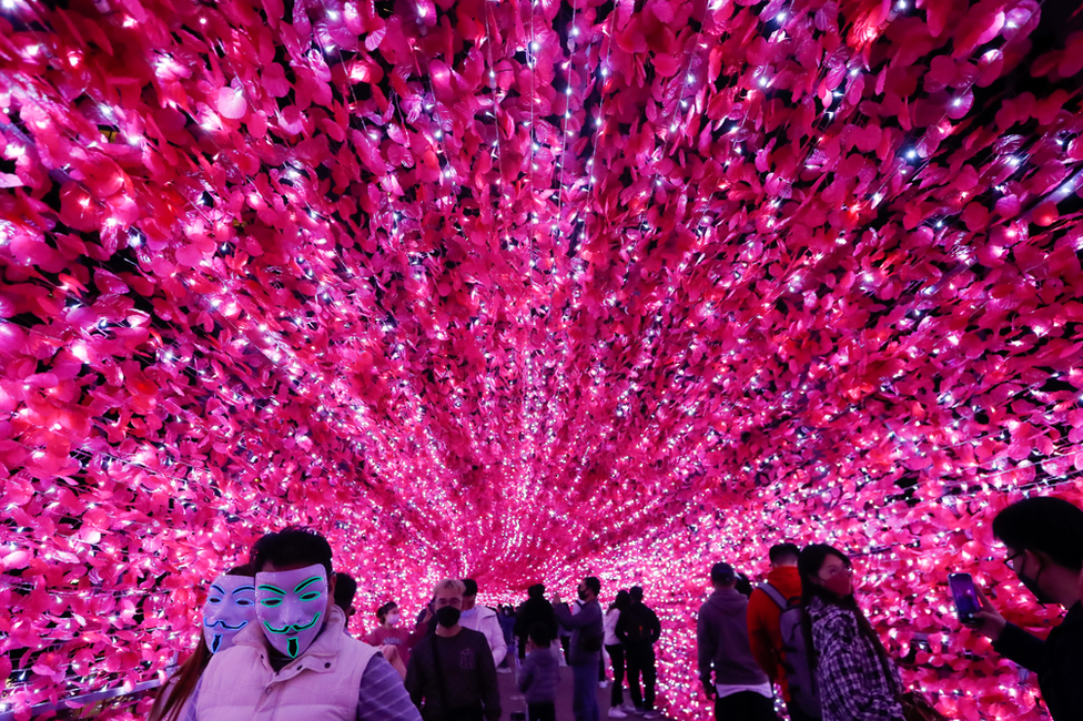 People take pictures on a footbridge with Christmas lights decorations in Taipei, Taiwan. Photo: 24 December 2021