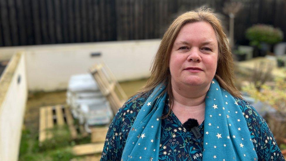 Karen Brown standing in her garden which resembles a pond