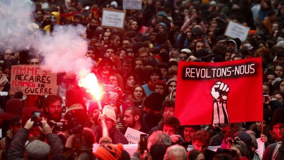 Protesters hold a sign reading "Let's Revolt" during a demonstration against pension reforms in Paris, France, 05 December 2019.