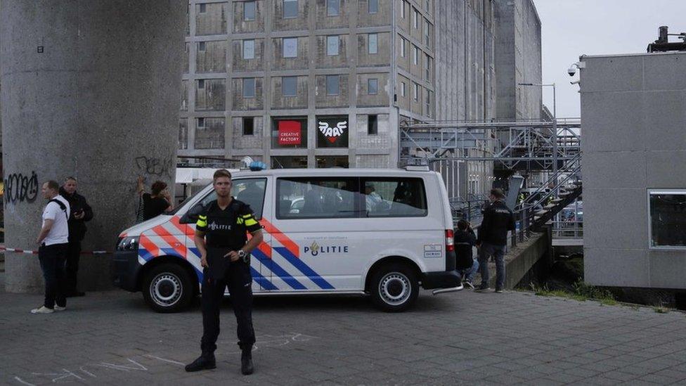 A policeman stands by as police evacuate the concert venue Maassilo on 23 August