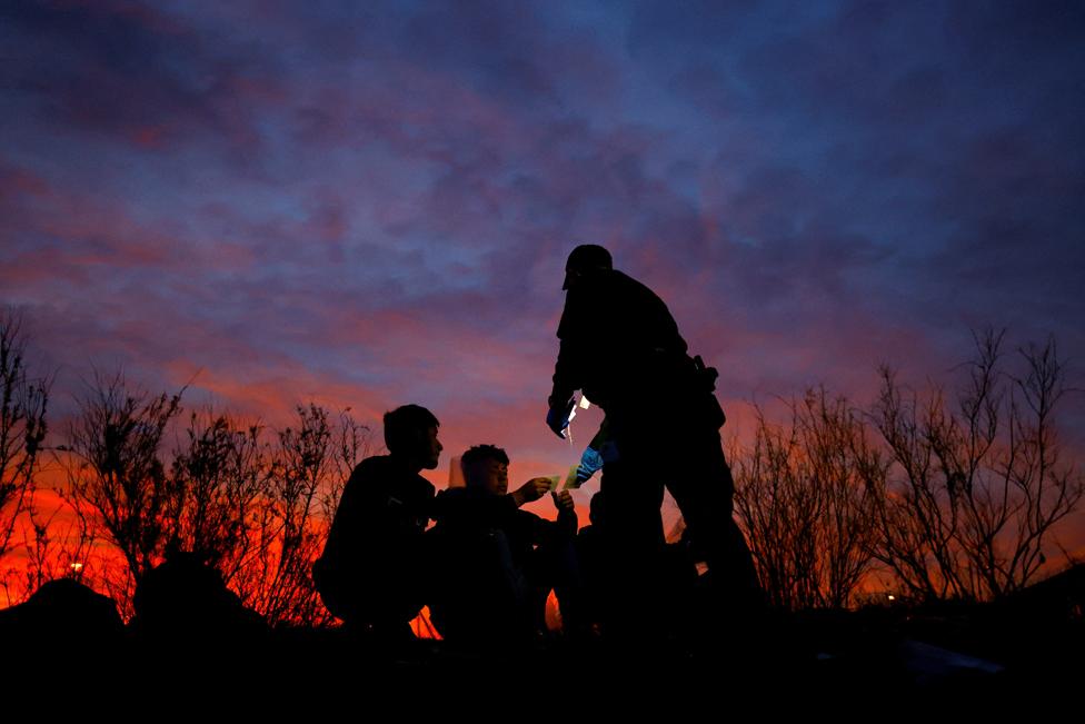 Migrants are detained by a U.S. Customs and Border Protection (CBP) agent after crossing into the United States from Mexico, in Sunland Park, New Mexico, U.S. March 23, 2023.