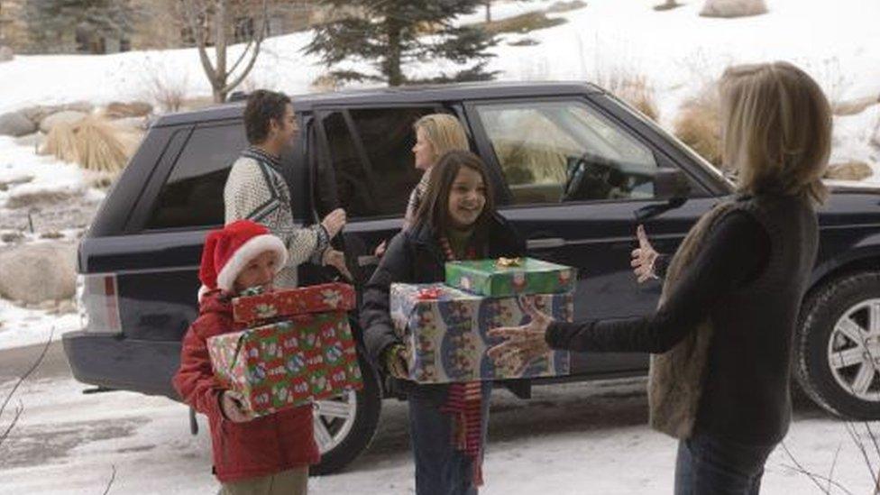 Family carrying Christmas presents