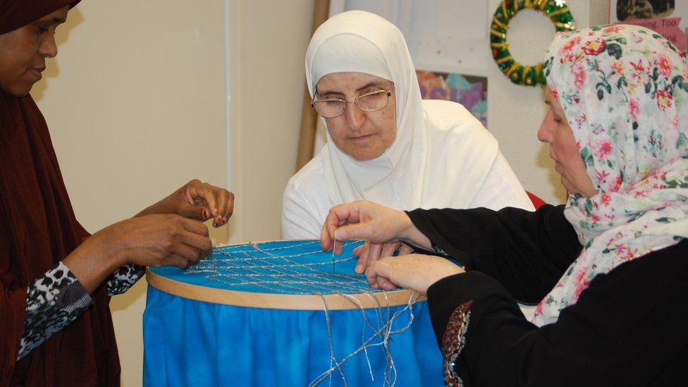 Women making the cage banner