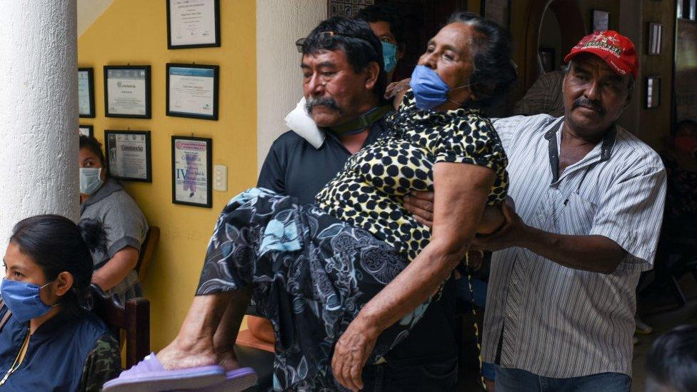 Relatives carry a woman with symptoms of Covid-19 in Chiapas state