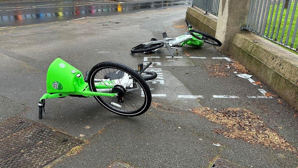 Bikes on the floor next to a designated parking bay