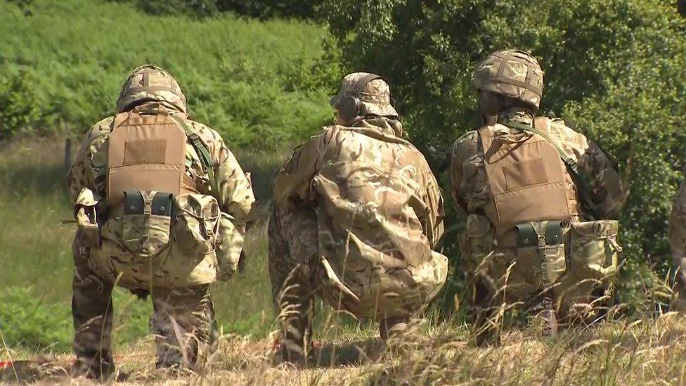 Three Ukrainian soldiers with their backs turned at an MOD base in the UK