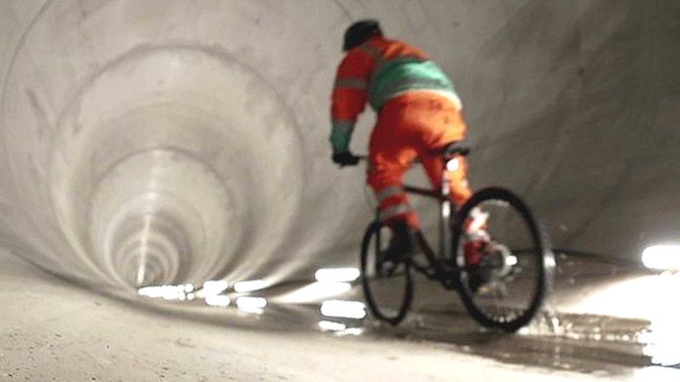 Jonah Fisher on a bike in super sewer tunnel