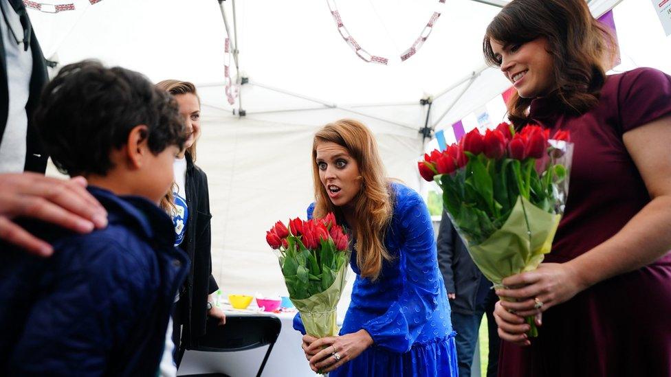 Princess Beatrice (centre) and Princess Eugenie are presented with flowers as they arrive at the Big Jubilee Lunch in Paddington