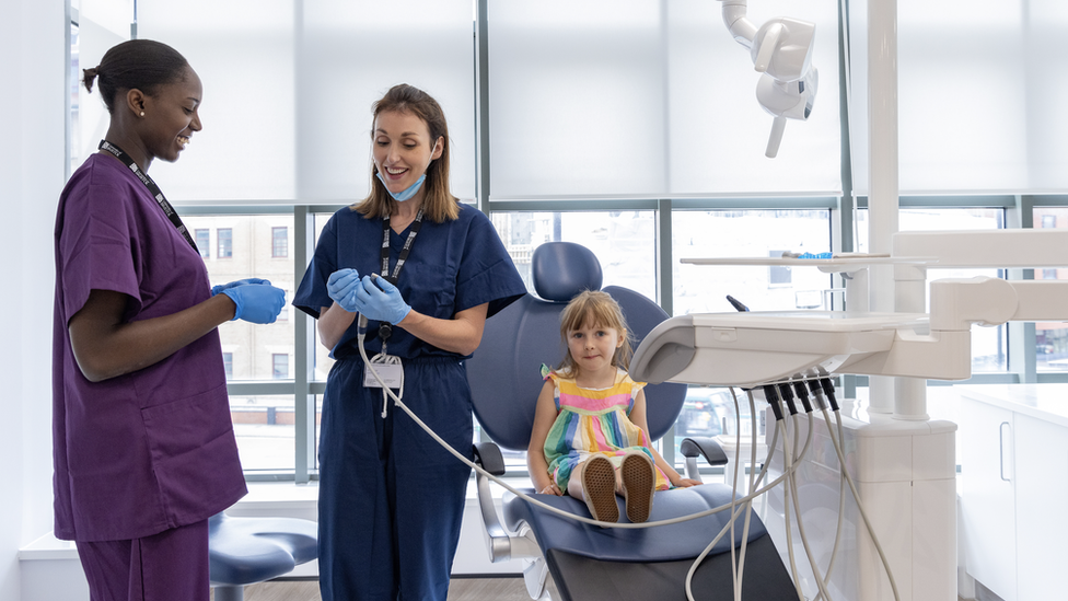 A student with clinician and patient on the Children's Clinic